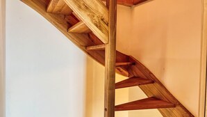 A wooden staircase with a simple design, leading to an upper floor.