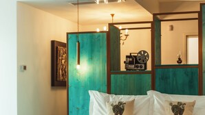 A bedroom with a bed, two pillows, a hanging light fixture, a wall-mounted clock, and a framed picture. - Da Riva Suite&Pool (Polignano a Mare)