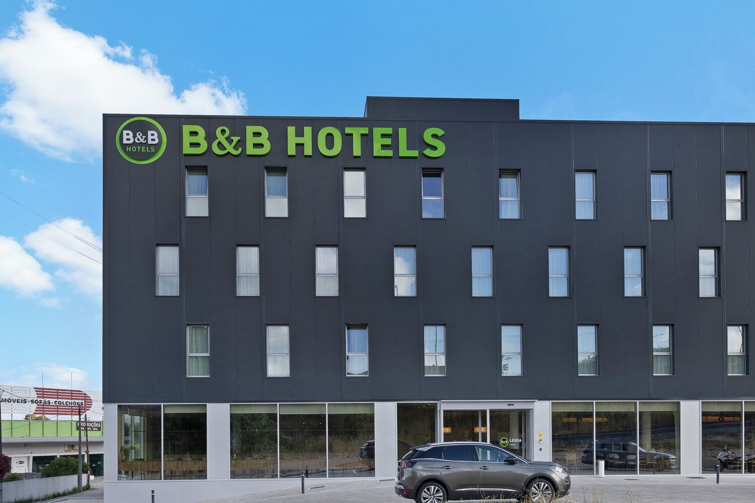 Ein modernes Bed & Breakfast Hotel mit dunkler Fassade und großen Fenstern.