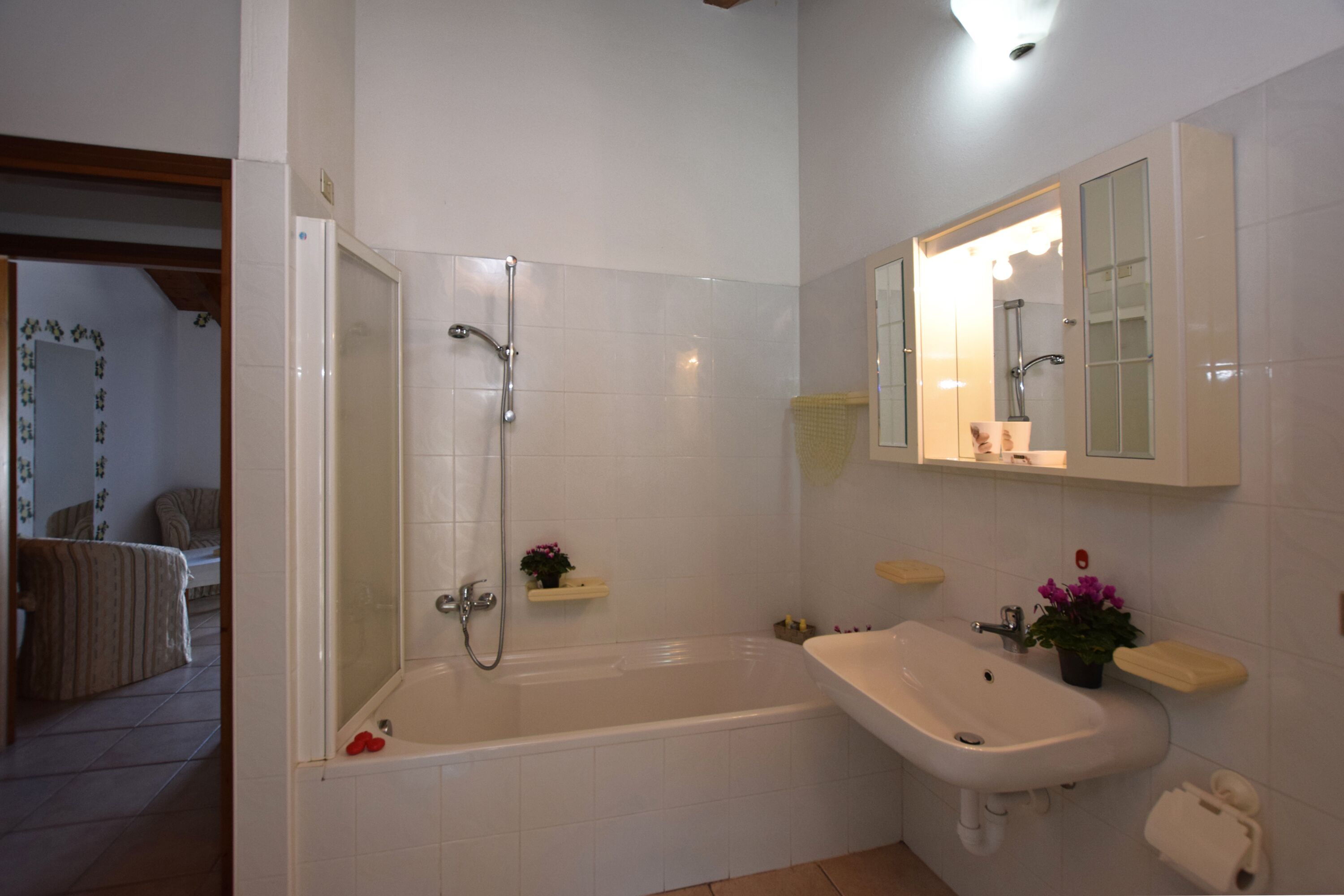 A bathroom with a bathtub, a sink, and a mirror.