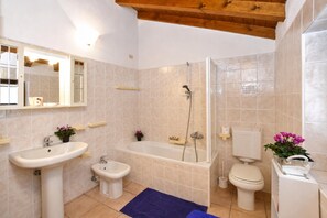 A bathroom with a sink, bidet, bathtub, toilet, and a mirror. - Belvedere in Colico (Colico)