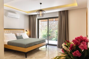 A bedroom with a bed, a window with curtains, a stone wall, and a potted plant.