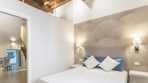 A modern bedroom with a large bed, two bedside lamps, and a patterned wall. - Ciambella Atmosphere apartment (Rome)