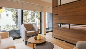 Ein modernes Wohnzimmer mit einer Couch, einem runden Couchtisch und einer Wand mit Holzvertäfelung.