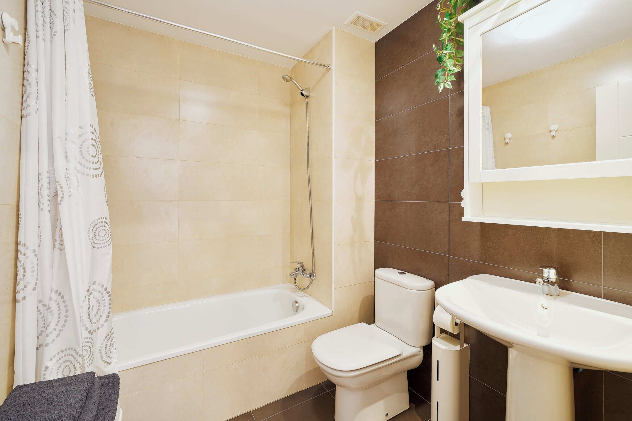 A bathroom with a bathtub, toilet, and sink.
