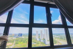 Una ventana con vistas a edificios altos y vegetación.