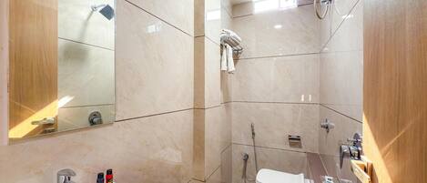 Een moderne badkamer met een wastafel, spiegel, douche en toilet.