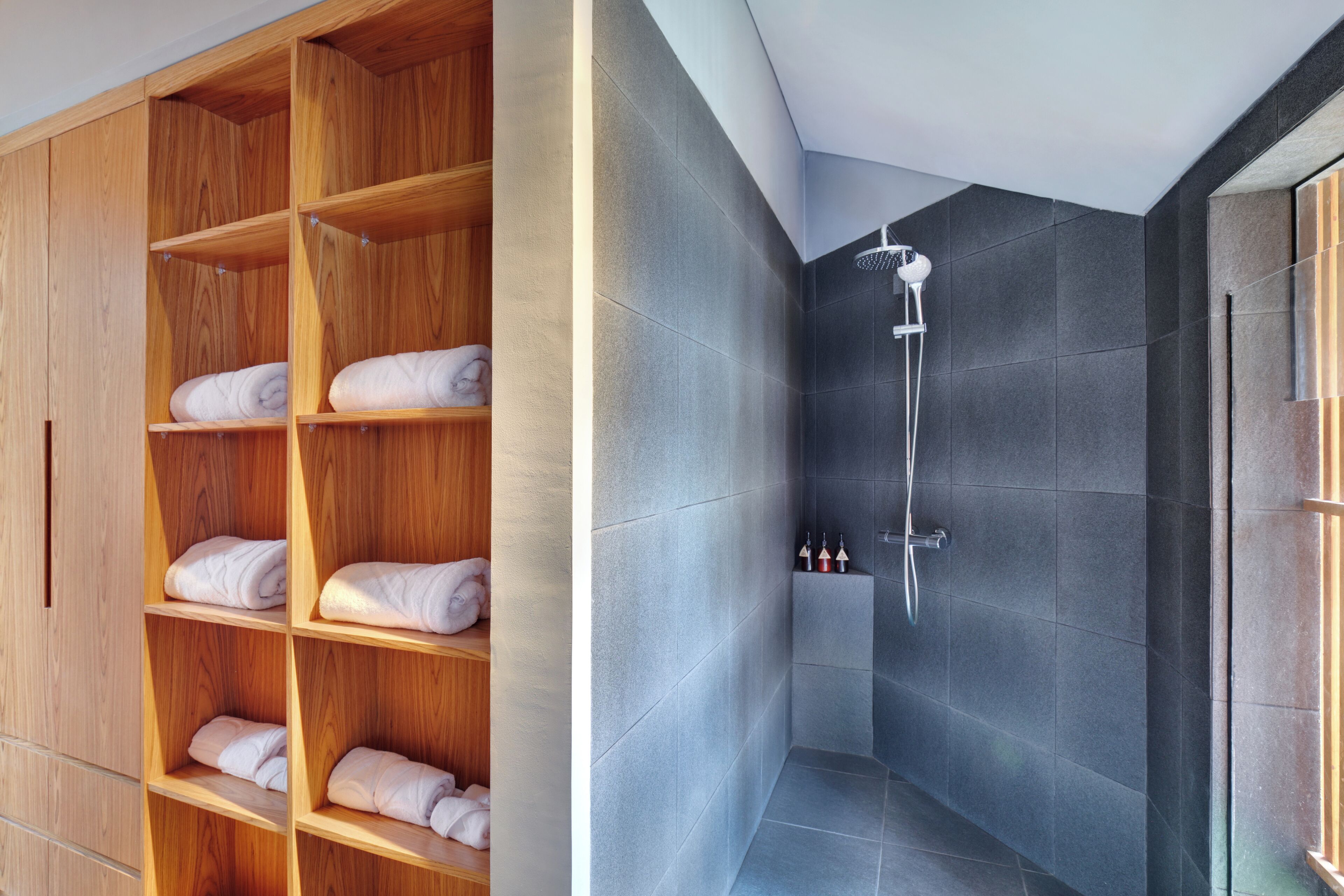 Een moderne badkamer met een houten wastafelmeubel en een inloopdouche.