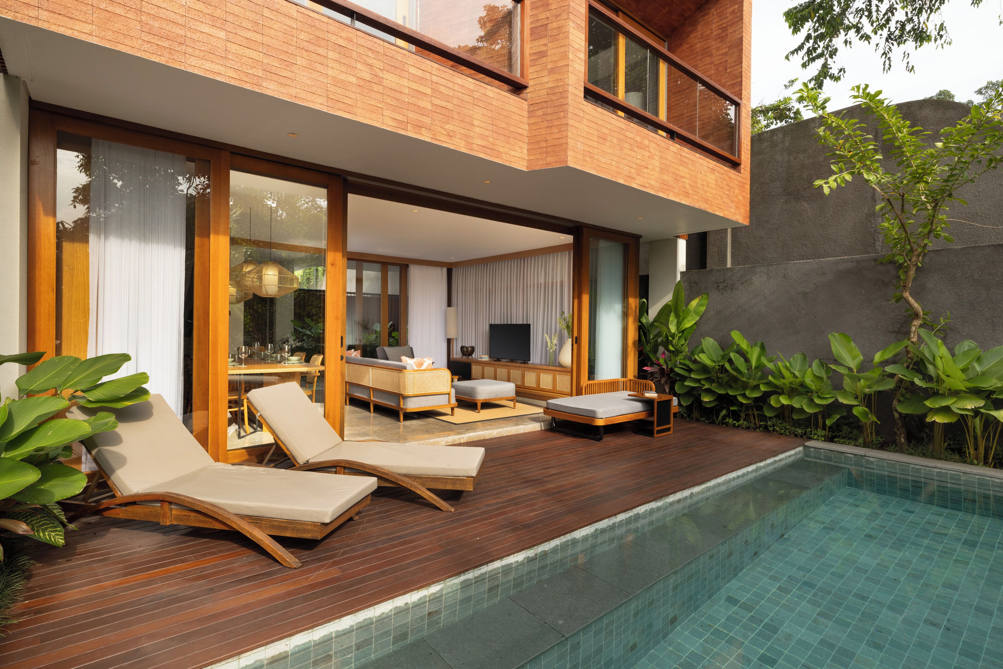 Una casa moderna con piscina, terrazza in legno e area relax all'aperto.