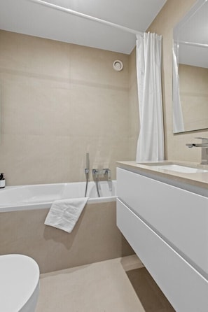 A modern bathroom with a bathtub, a sink, and a toilet.