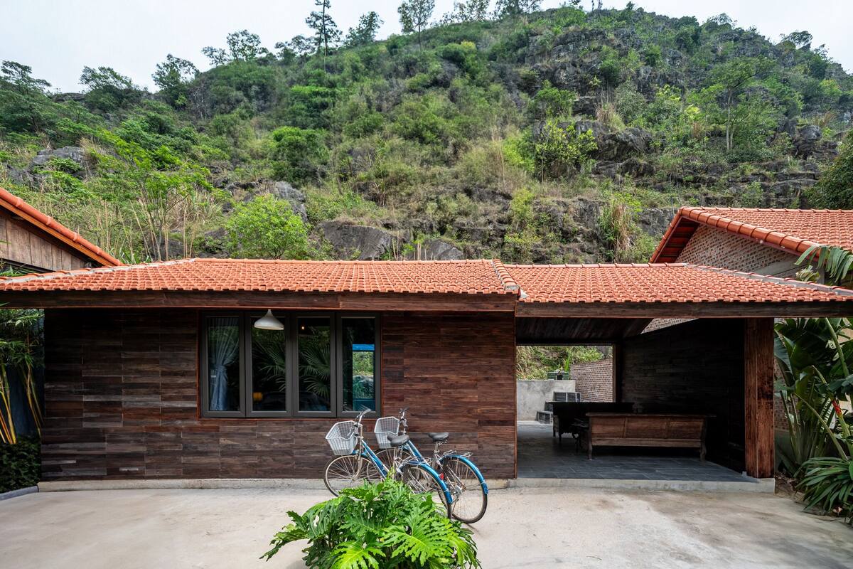 A modern building with a tiled roof, wooden walls, and a concrete patio.