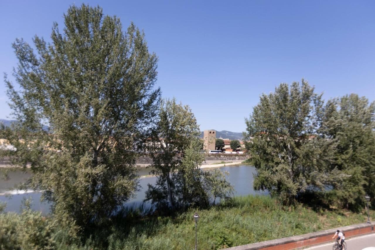 Un fiume con alberi e un edificio sullo sfondo.