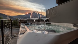 A hot tub with two glasses of wine on a balcony overlooking a mountainous landscape during sunset. - Condo with Private Hot Tub and Balcony Views | 5 Minutes to Ski Base (Big Sky)