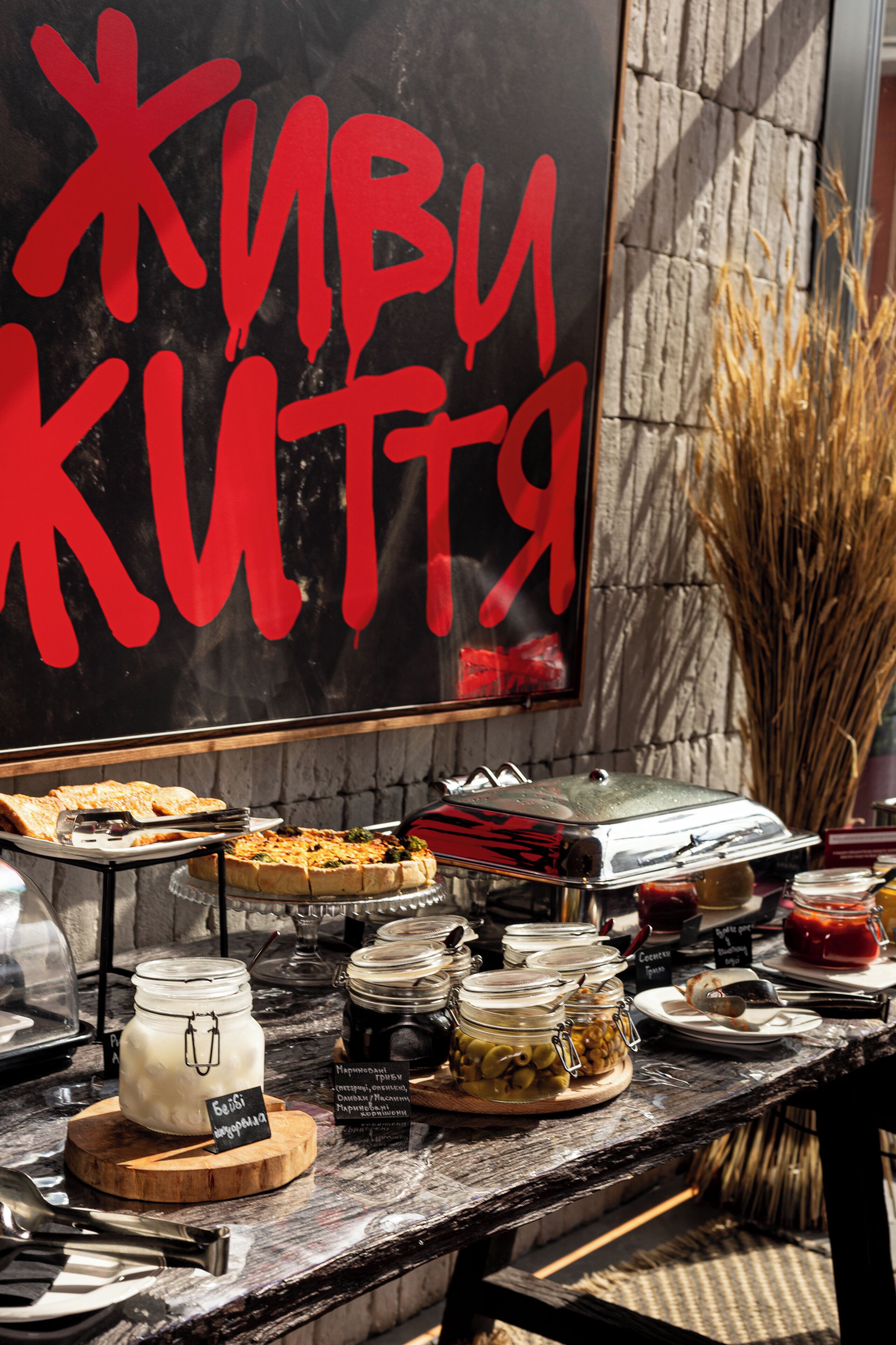 A buffet setup with various food items and a sign with red text.