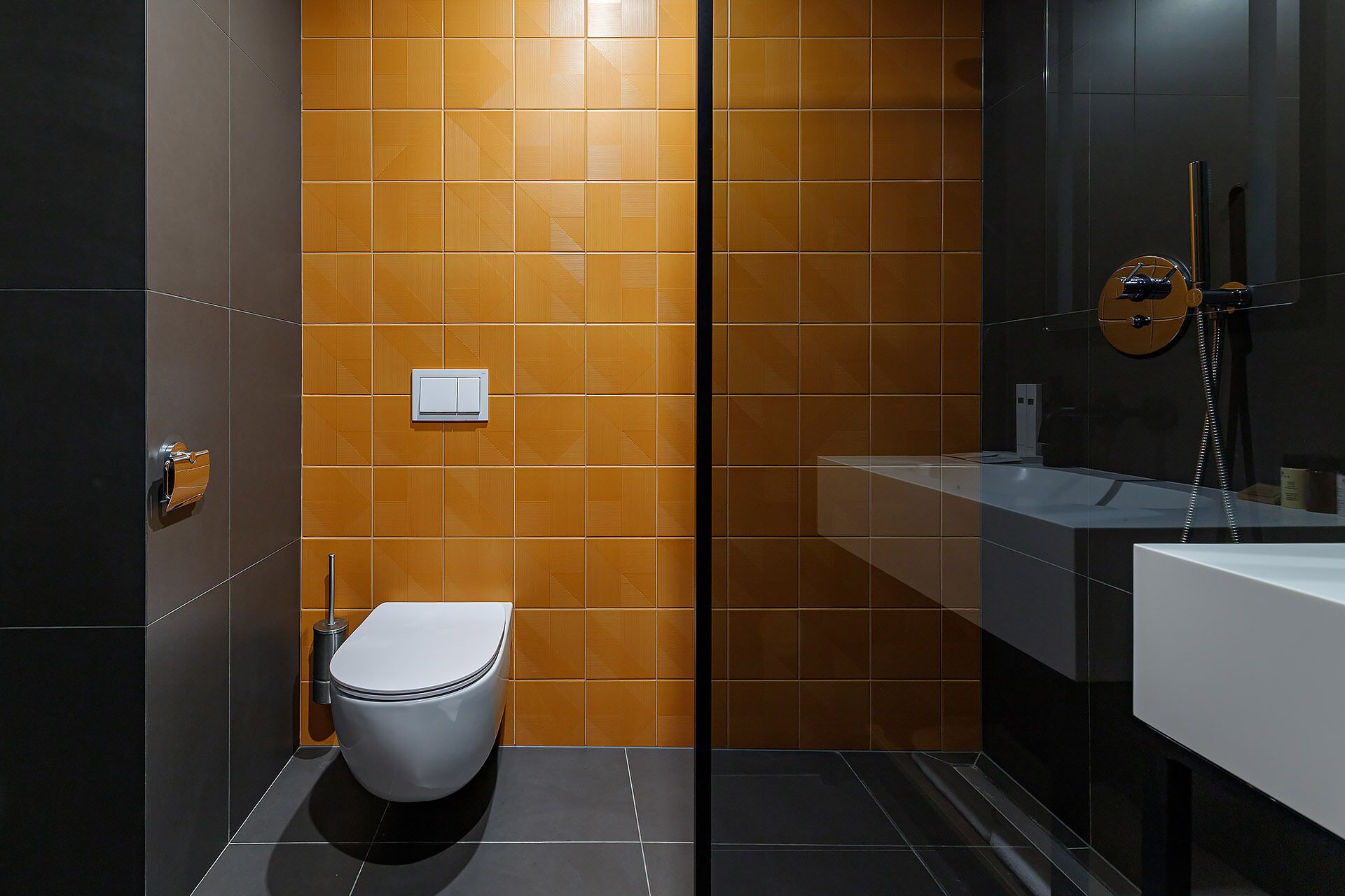 A modern bathroom with a toilet, a sink, and a shower.