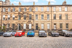 A row of terraced houses with parked cars in front. - Georgian Gem in the New Town (Edinburgh)