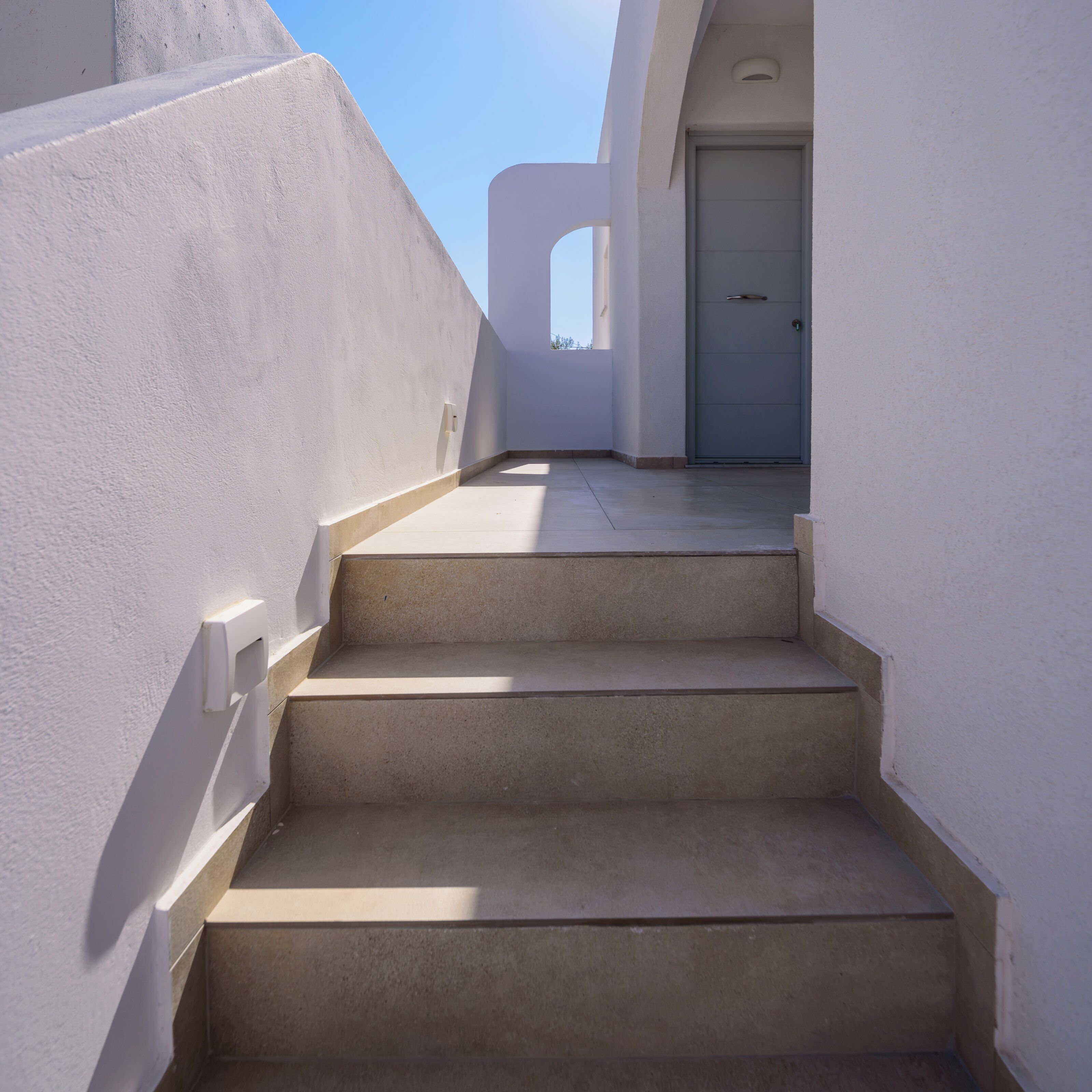 A set of beige concrete stairs leading up to a door.