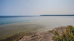 A coastal landscape with a clear view of the sea and a distant shoreline.