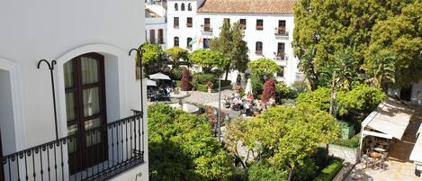A courtyard with a fountain, seating areas, and a view of surrounding buildings.