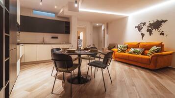 Un salon moderne avec un coin repas, comprenant un canapé, des fauteuils et une carte du monde accrochée au mur.