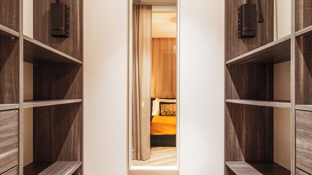 A narrow hallway with wooden shelving on both sides and a small window at the end. - VL Luxury Apartment (Polignano a Mare)