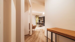 A modern kitchen with a wooden countertop and a dining area with a chair and table. - VL Luxury Apartment (Polignano a Mare)