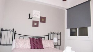 Une chambre à coucher avec un lit, une table de chevet, une lampe et une fenêtre avec un store.