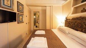 A hotel room with a bed, a TV, and framed pictures on the wall. - Boccaccio 22 - 4 (Roma)