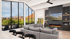 Uma sala de estar moderna com um amplo sofá modular, uma lareira e uma televisão grande.