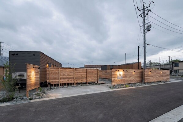 A modern building with a wooden fence and a paved entrance.