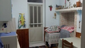 A compact kitchen with a refrigerator, stove, and a small dining area with a table and chairs. - Blue Mansion, Plomari, Lesvos Island, Greece (Plomari)