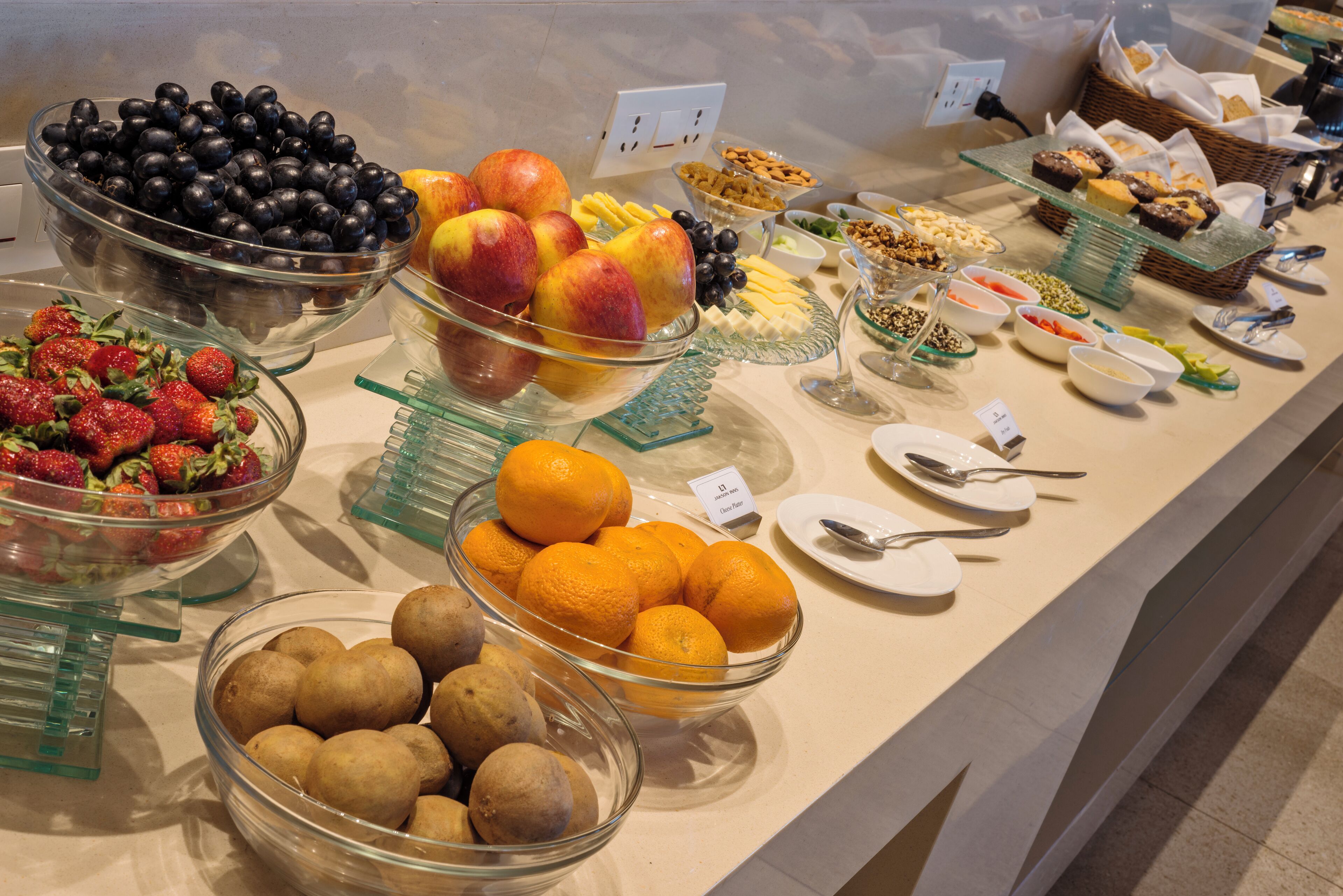 A buffet with various fruits, including strawberries, blueberries, apples, and oranges.