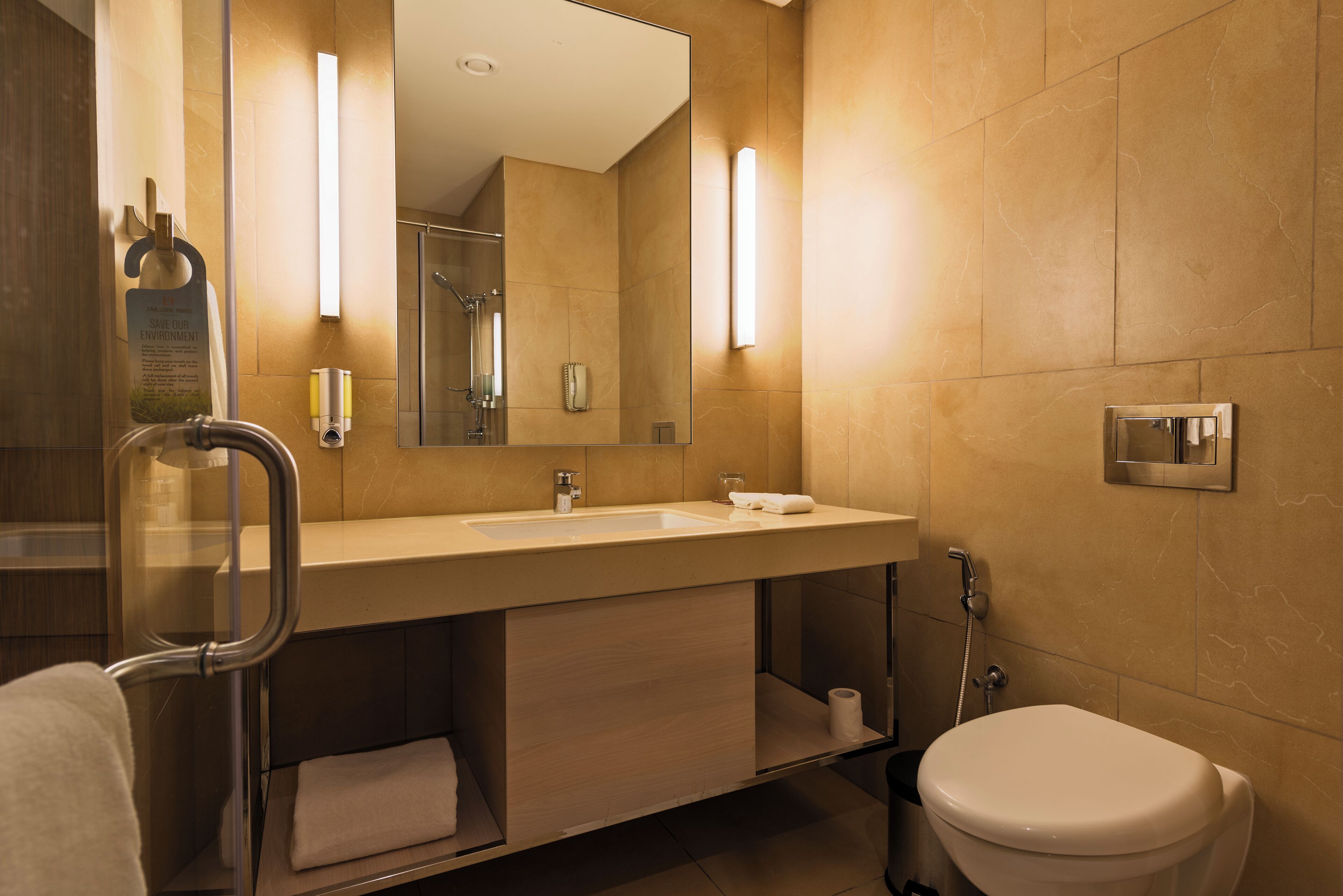 A modern bathroom with a sink, mirror, towel rack, and toilet.