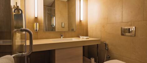 A modern bathroom with a sink, mirror, towel rack, and toilet.