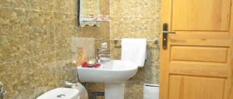 Un baño con inodoro, lavabo y espejo.