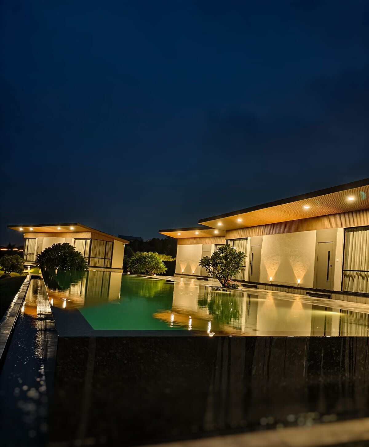 A modern house with a swimming pool at dusk.