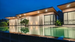 A modern hotel with a pool, featuring a two-story structure with large windows and a flat roof. - River's Edge By Escape Stays (Nashik)