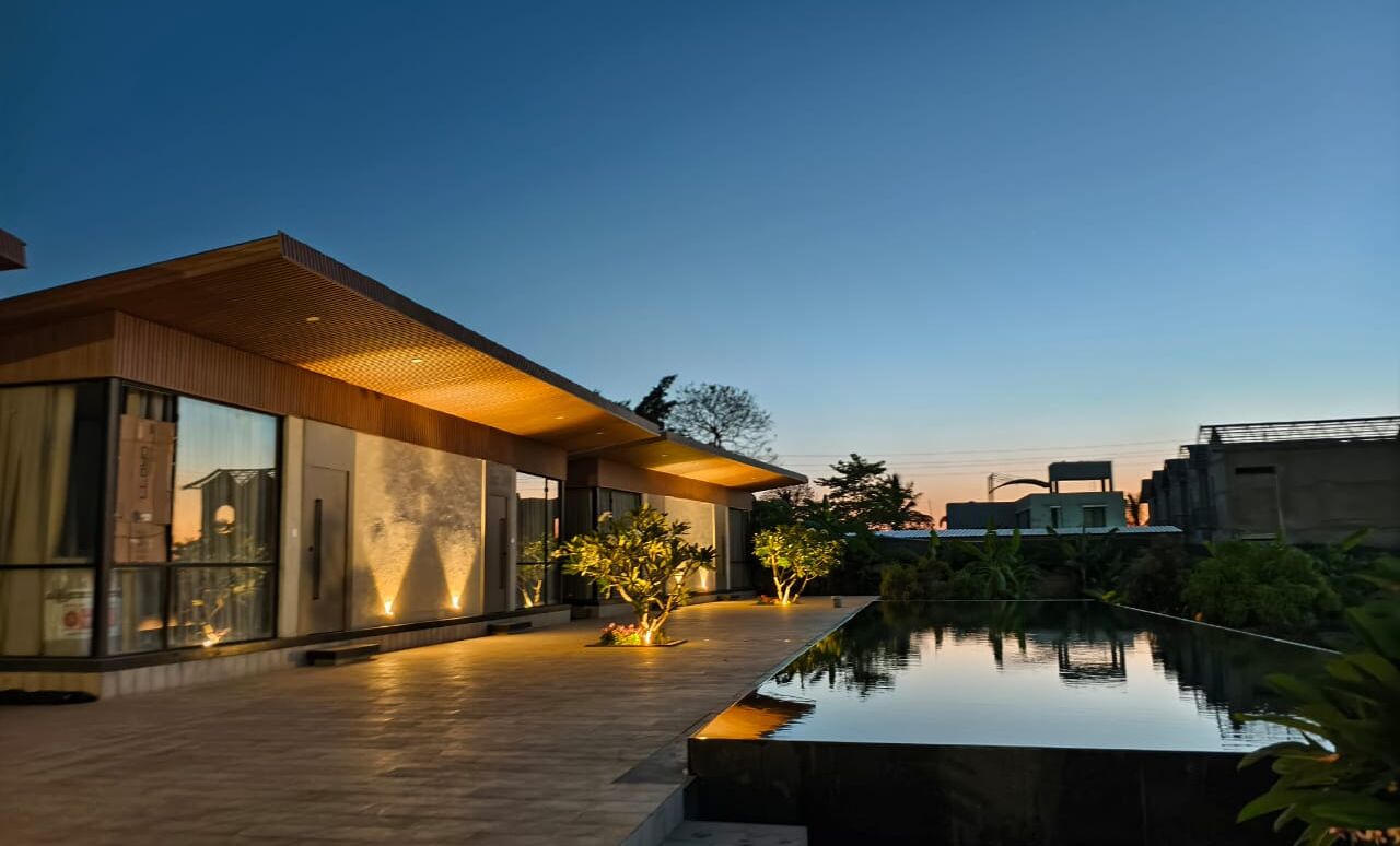 A modern building with large windows and a pool.