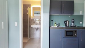 A modern kitchen with a built-in microwave, coffee maker, and a sink. - triple a Apartments in Altfeld (Marktheidenfeld)
