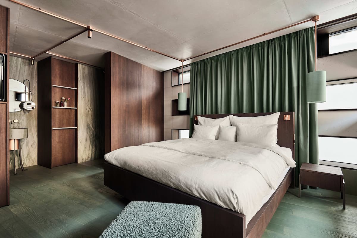 Un dormitorio moderno con una cama grande, un armario de madera y una mesita de noche.