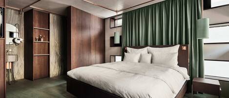 Une chambre à coucher moderne avec un grand lit, une armoire en bois et une petite table de chevet.