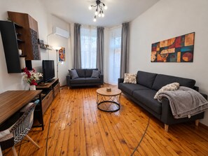 A modern living room with a sofa, a coffee table, and a TV. - NDK Top Center Sofia Two Bedroom Apartment with ACC (Sofia)