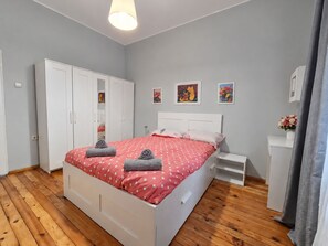 A bedroom with a bed, wardrobe, bedside table, and artwork on the wall. - NDK Top Center Sofia Two Bedroom Apartment with ACC (Sofia)