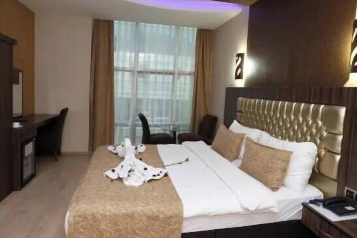 A hotel room with a bed, a desk, and a chair.