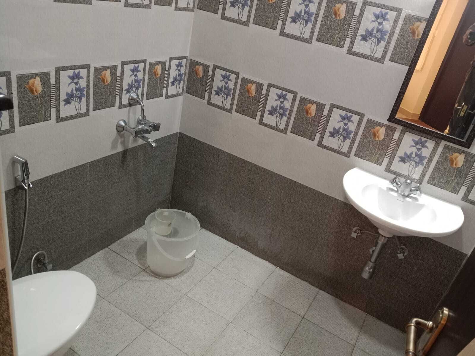 Um banheiro pequeno com vaso sanitário, pia e chuveiro.