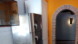 Een keuken met een roestvrijstalen koelkast, witte kastjes en een houten aanrecht.