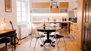 A modern kitchen with a dining table, chairs, and various appliances. - The Bright Nest Aquarium - Genoa Historical Center (Genova)