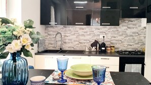 Een moderne keuken met zwarte kastjes, een betegelde spatwand en een gasfornuis.