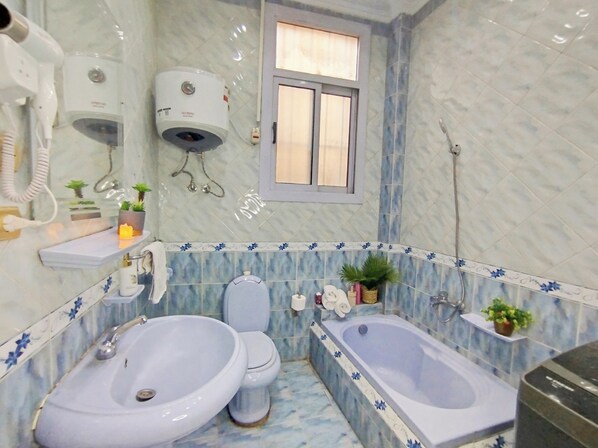 Un bagno con due lavandini, un water, una vasca da bagno e una finestra.
