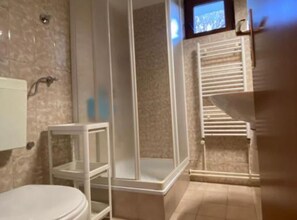 A bathroom with a toilet, a shower enclosure, and a built-in sink. - Apartment Nonna (Seget)